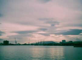 Harbor with boats and buildings under cloudy sky